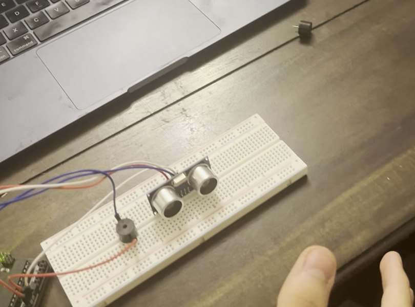 HC-SR04 sensor and buzzer on a breadboard with a hand approaching